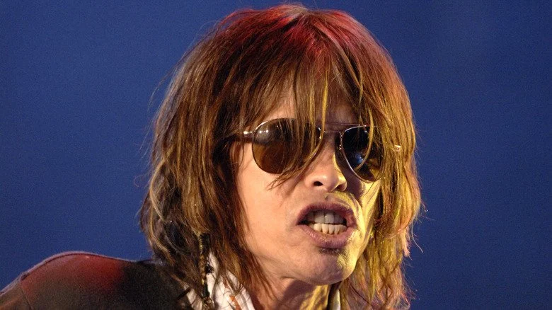 Steven Tyler portant des lunettes de soleil sur scène en 2006