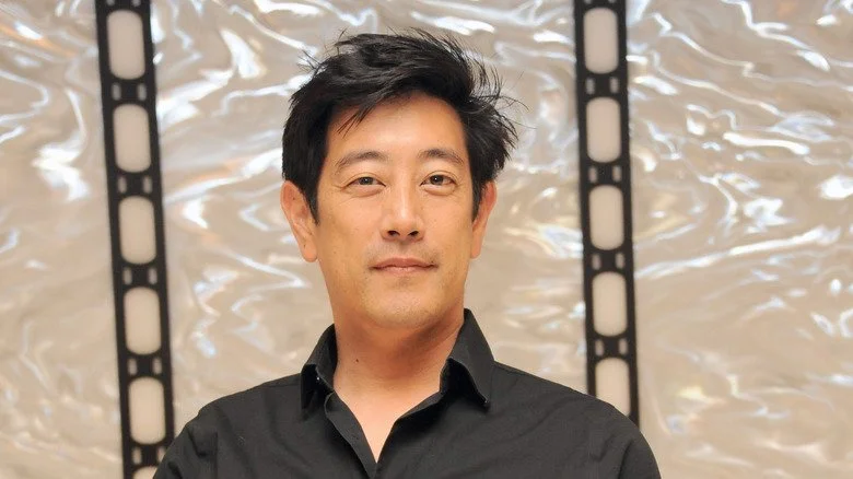 Grant Imahara posant avec un t-shirt noir