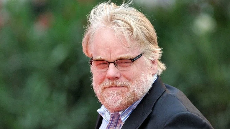 Philip Seymour Hoffman plissant les yeux, regard détourné, cheveux au vent