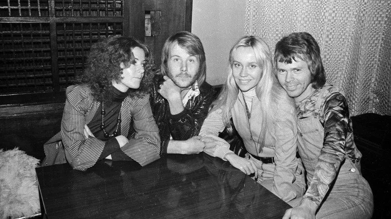 Members of the band ABBA seated at a table