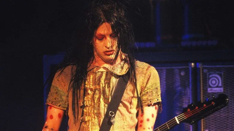 Twiggy Ramirez jouant de la basse sur scène avec de longs cheveux