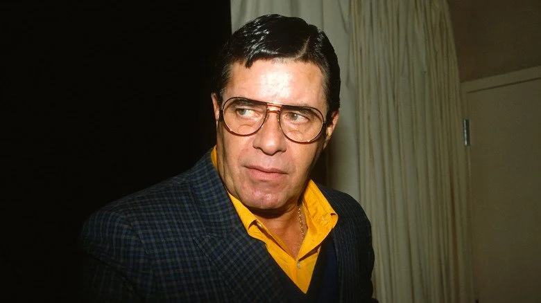 Jerry Lewis portant des lunettes, avec un rideau en arrière-plan