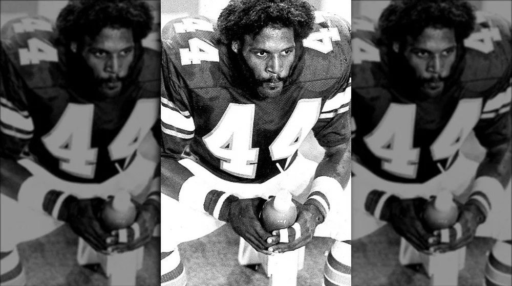 Joe Delaney accroupi