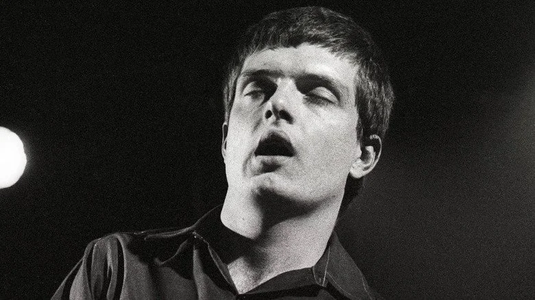 Ian Curtis les yeux fermés dansant sur scène