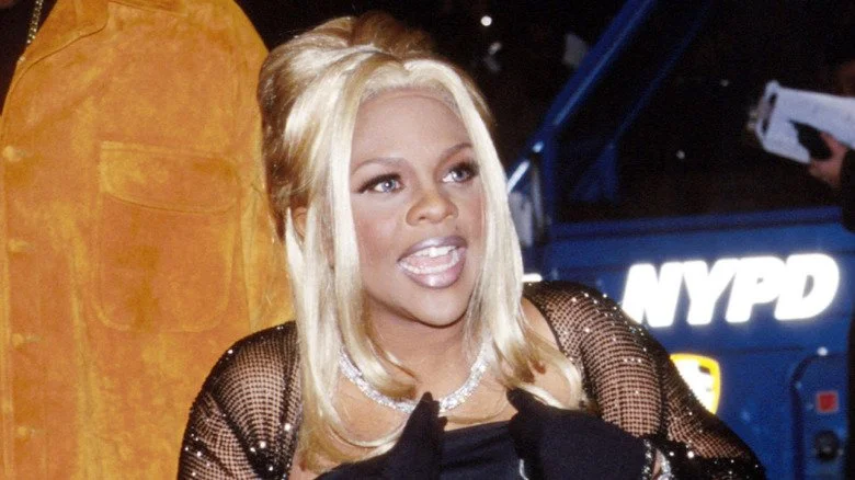 Lil' Kim dans les années 90, parlant et regardant au loin