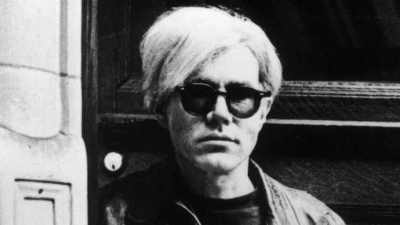 Andy Warhol se tenant à l'intérieur d'une porte