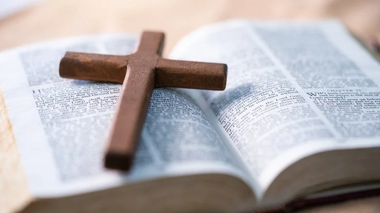 Croix en bois simple posée sur une Bible