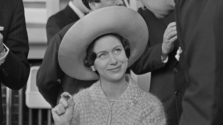 Princess Margaret assise, souriante avec un large chapeau lors d'un événement
