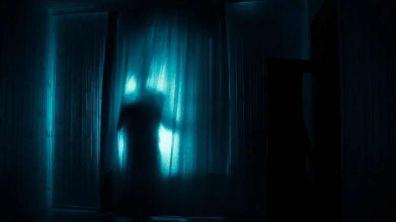 Personne inquiétante devant une maison