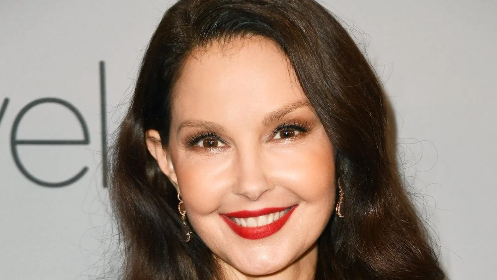 Ashley Judd souriante, portant un rouge à lèvres rouge