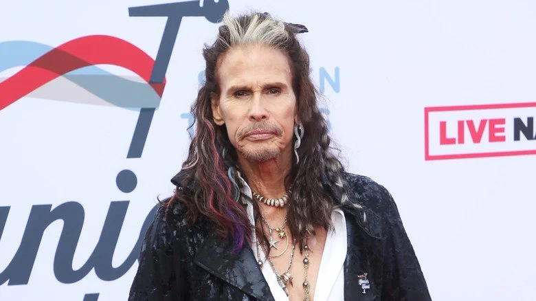 Steven Tyler posant devant un fond multicolore en 2022