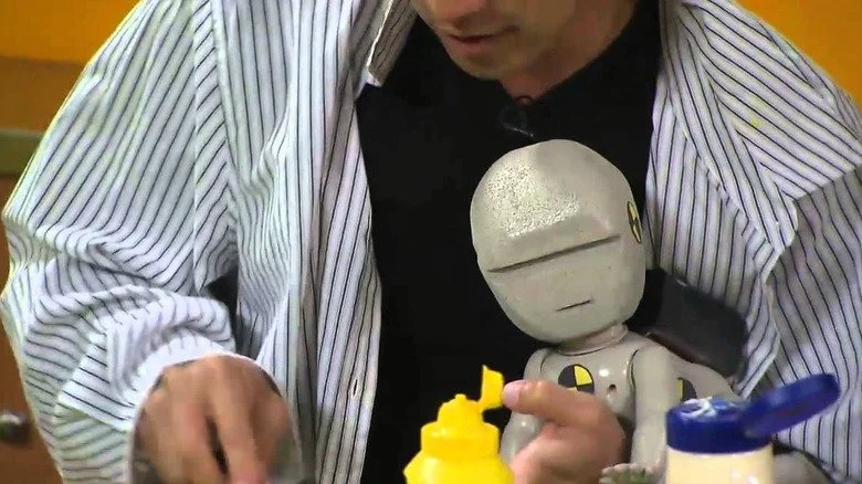 Un volontaire des MythBusters tenant un robot bébé en gros plan