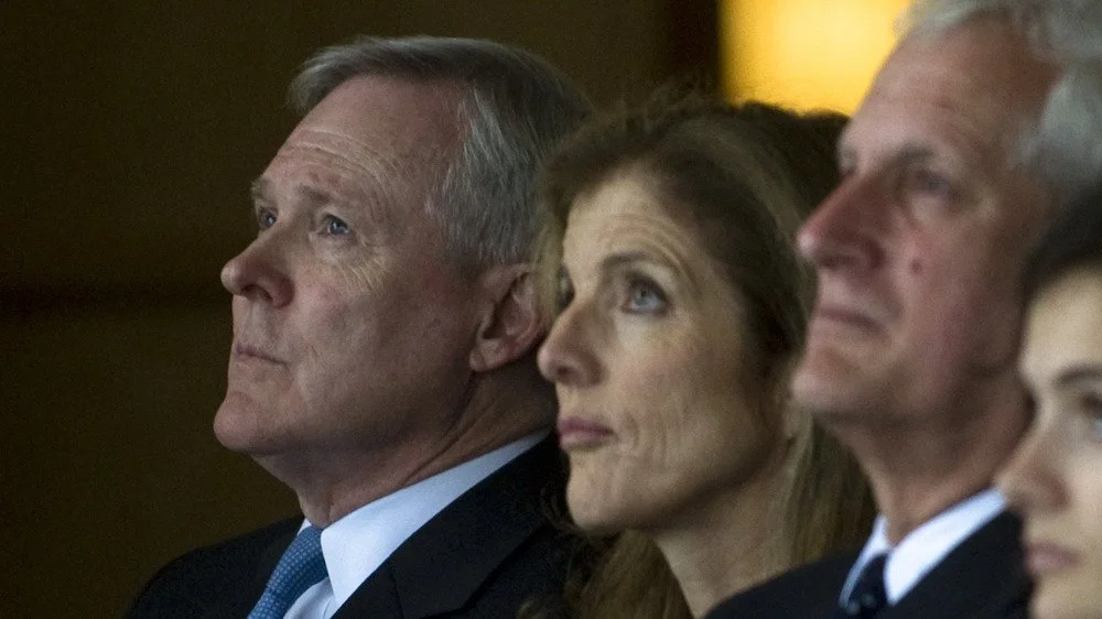 Ray Mabus assis à côté de Caroline Kennedy, tous deux regardant vers le haut