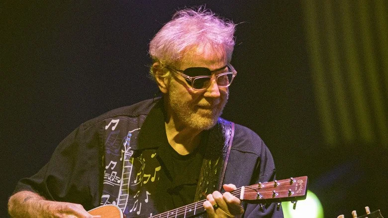 Richard Williams de Kansas joue de la guitare en portant des lunettes et un cache-œil
