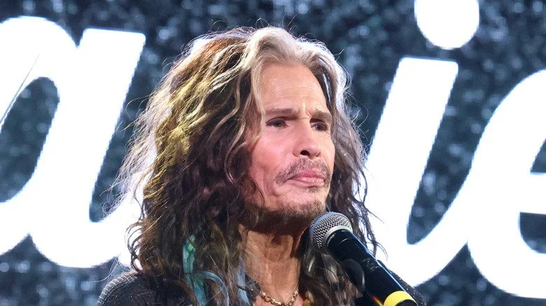 Gros plan de Steven Tyler debout à un pupitre