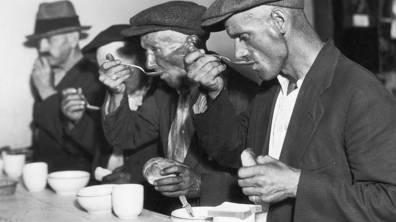 Hommes de la Grande Dépression mangeant à une file d'attente de nourriture