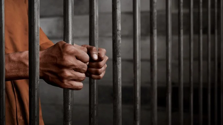 un homme derrière les barreaux