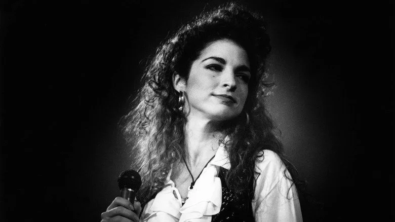 Gloria Estefan onstage with microphone in 1990