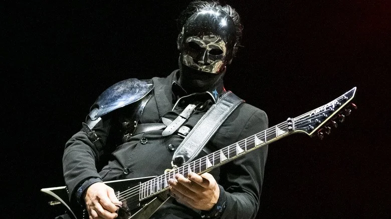 Wes Borland jouant de la guitare sur scène avec un masque brillant