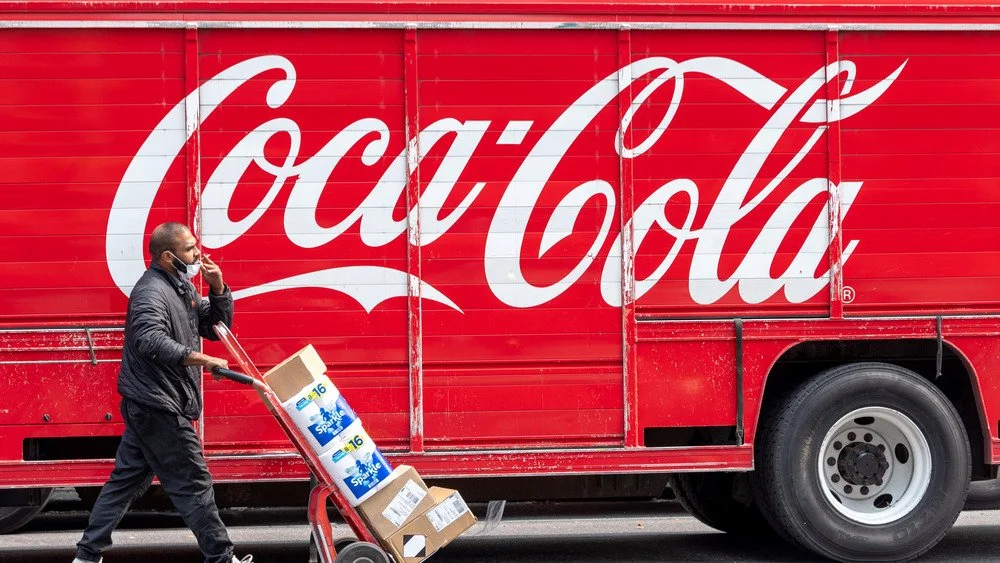 Un ouvrier déchargeant un camion Coca-Cola