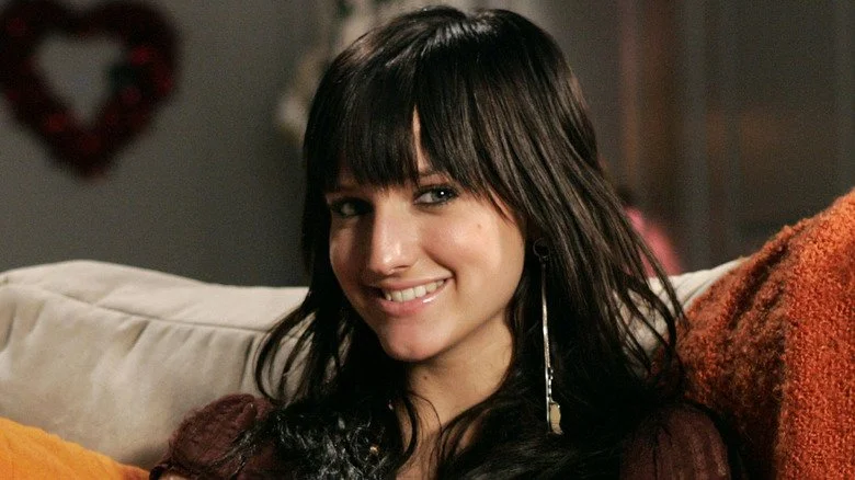 Ashlee Simpson assise sur un canapé, souriant à la caméra