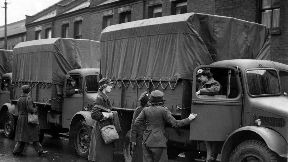 Camions militaires avec des femmes militaires montant à bord