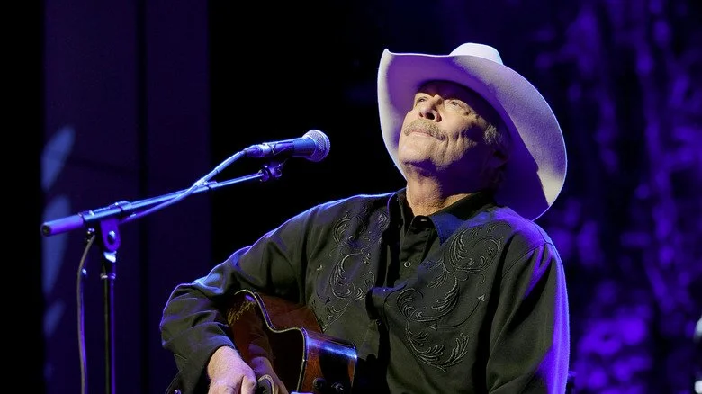 Alan Jackson en performance sur scène, portant une chemise noire