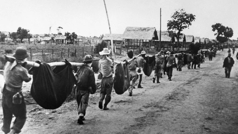 Soldat allié portant un blessé pendant la marche de la mort de Bataan