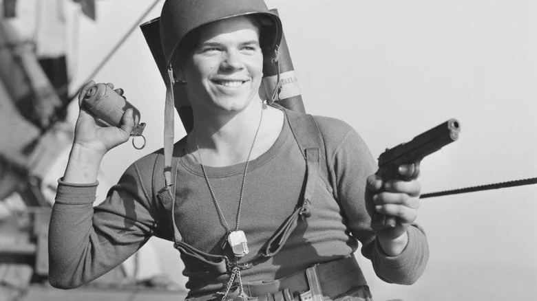 Soldat tenant une grenade et une arme, souriant