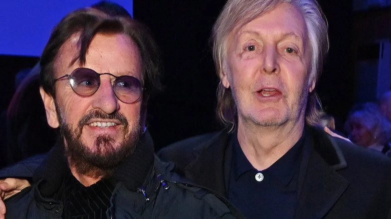 Ringo Starr souriant regardant au-delà de Paul McCartney