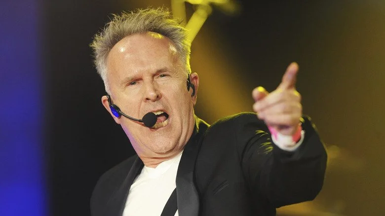 Howard Jones pointant du doigt en chantant lors d'un concert