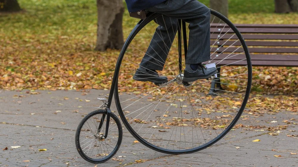 Homme roulant sur un penny farthing