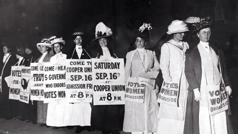 Suffragettes en chapeaux élégants manifestant pour le droit de vote