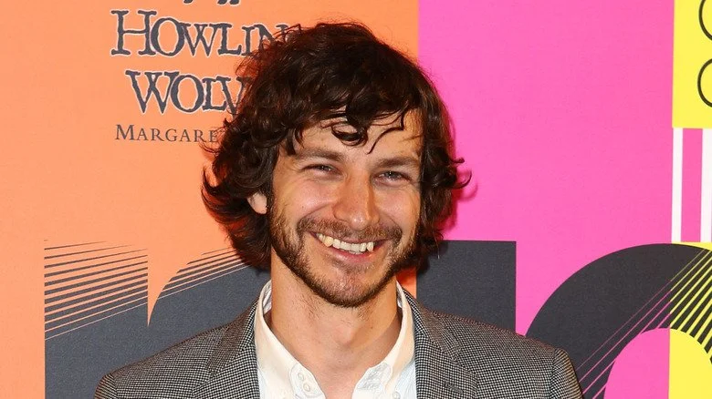 Gotye souriant avec barbe et cheveux en désordre