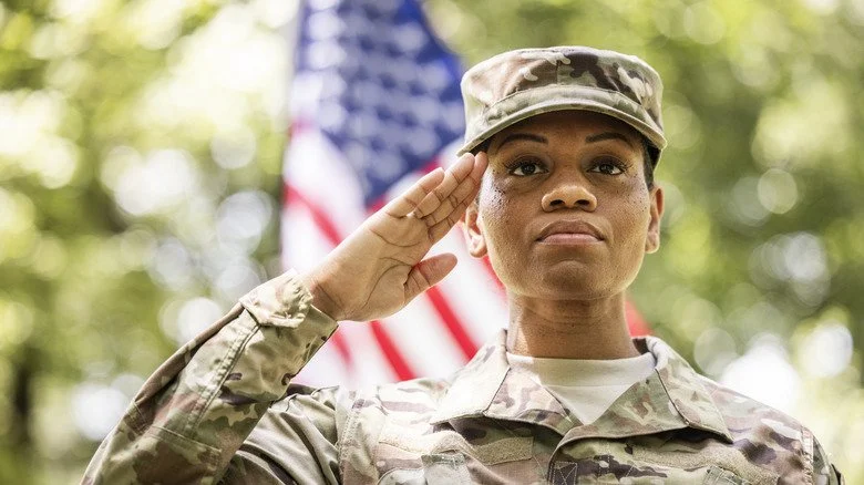 Soldate saluant devant un drapeau américain