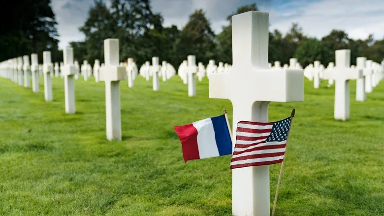Croix dans un cimetière militaire avec un drapeau américain et français