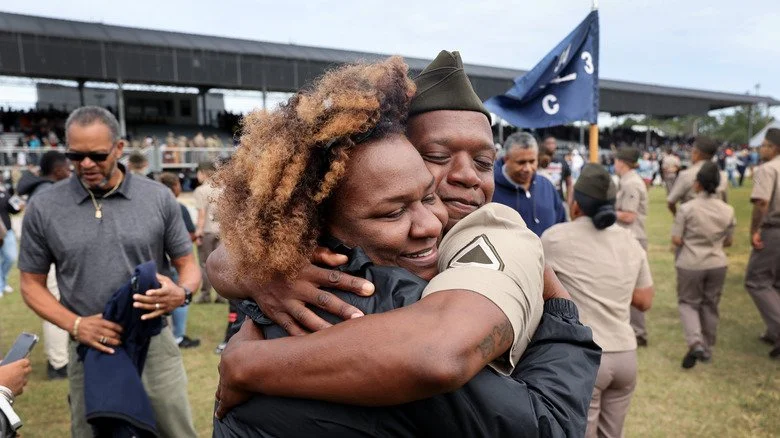 Un cadet de l'armée nouvellement diplômé embrassant un proche