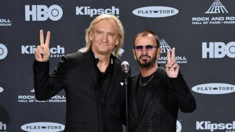 Joe Walsh posant avec Ringo Starr, tous deux vêtus de noir
