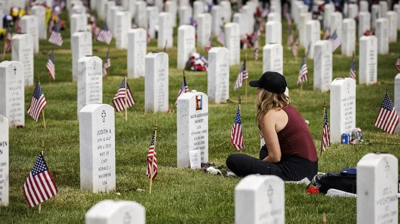 Femme assise près d’une tombe au cimetière d’Arlington lors du Memorial Day