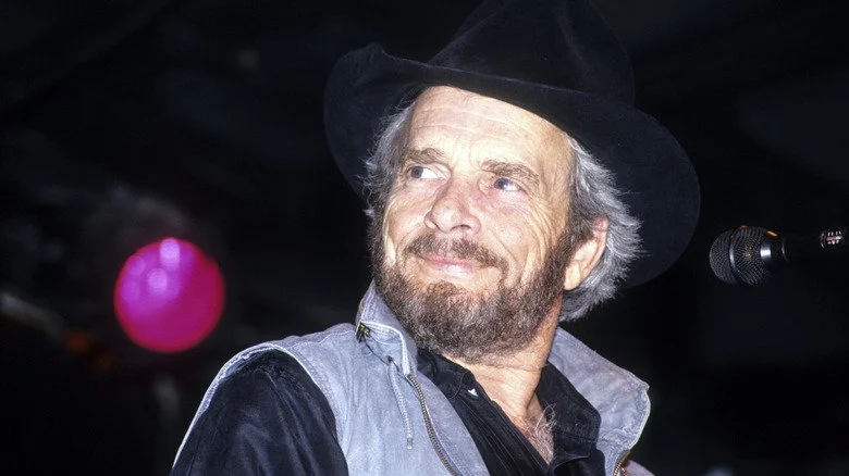 Merle Haggard souriant avec un chapeau de cowboy