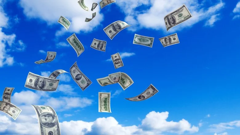 Billets de banque volant dans un ciel bleu