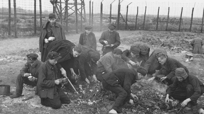 Des prisonniers de guerre alliés fouillant les cendres à la recherche de nourriture