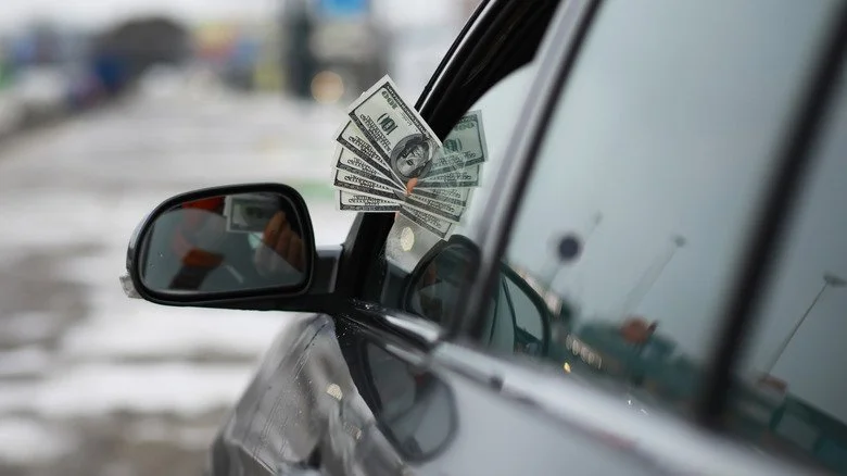 Argent dépassant d'une fenêtre de voiture