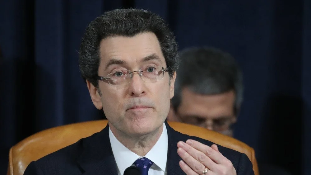 Conseiller principal Norm Eisen assis