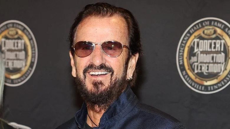 Ringo Starr souriant avec des lunettes de soleil