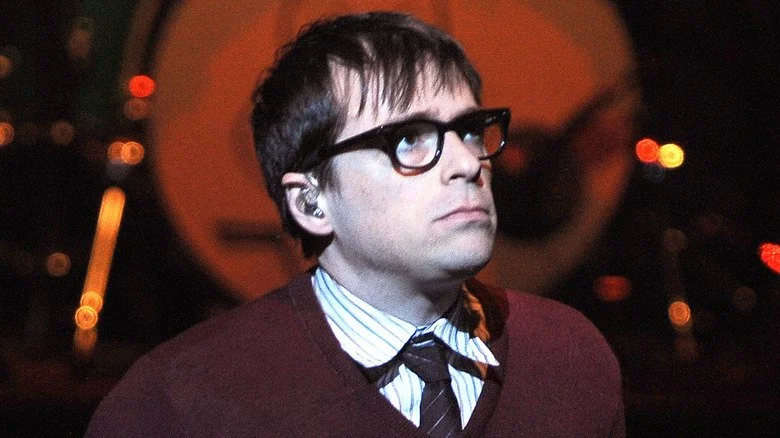 Rivers Cuomo sur scène dans les années 90, portant un pull et regardant vers le haut