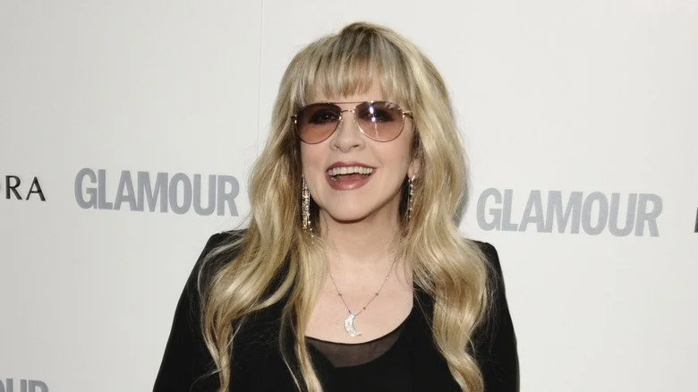 Stevie Nicks souriante avec des lunettes de soleil