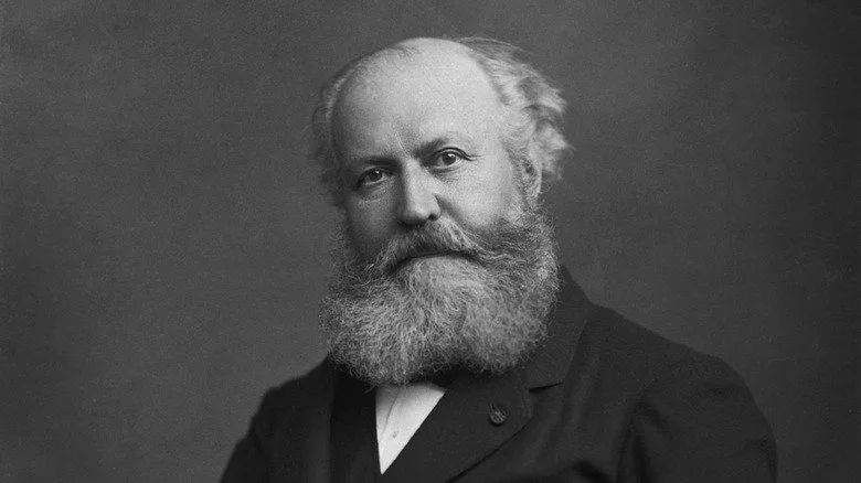 Charles Gounod assis avec barbe en costume sombre