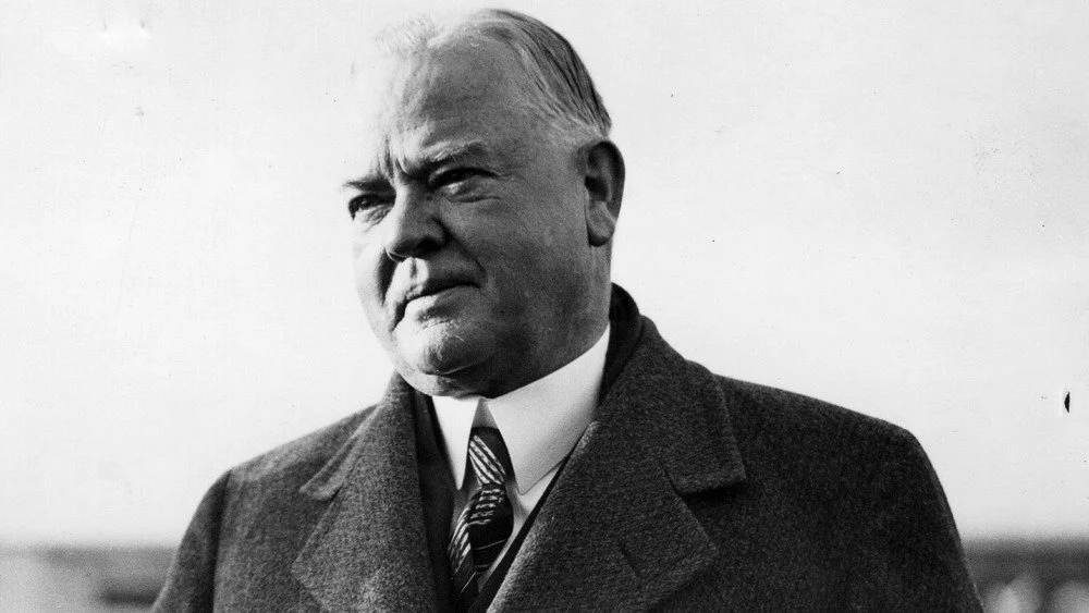 Le président américain Herbert Hoover plissant les yeux