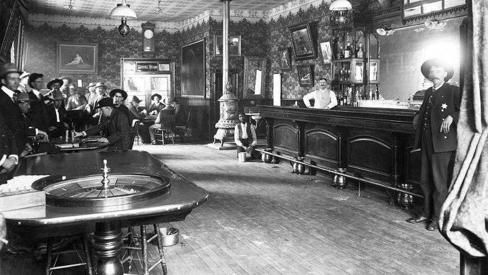 Bar avec une roue de roulette et des hommes jouant